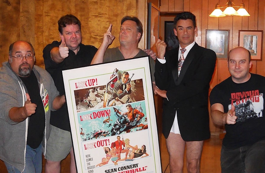The Damn Dirty Geeks take on James Bond: (L to R) Frank Woodward, Scott Weitz, Frank Dietz, Daran Norris and Jack Bennett pose with Daran's THUNDERBALL poster