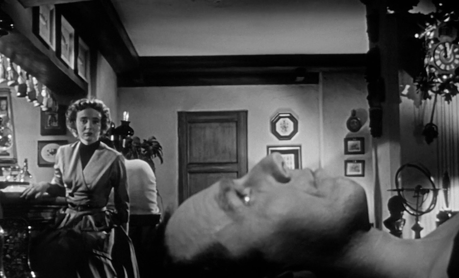 Left alone with the doppelganger body (King Donovan), Teddy (Carolyn Jones) is horrified to see it open its eyes, in INVASION OF THE BODY SNATCHERS.
